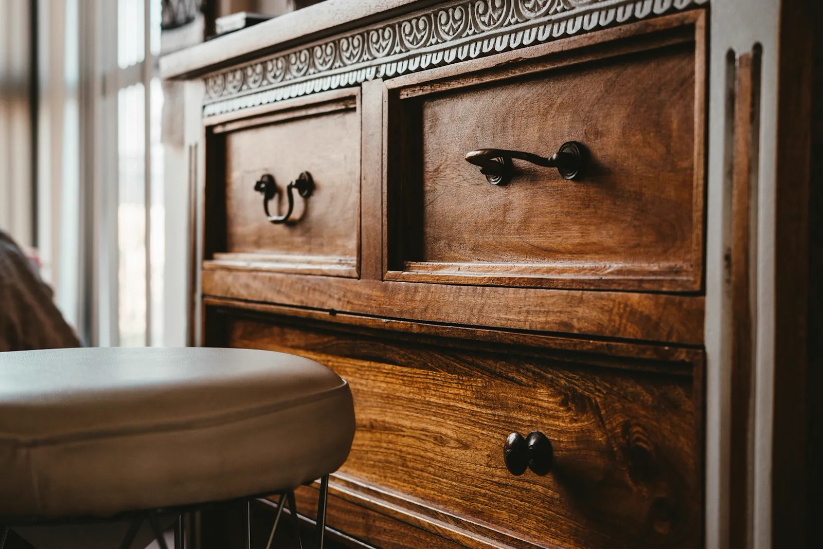 Antique wooden dresser with carved trim and brass drawer pulls