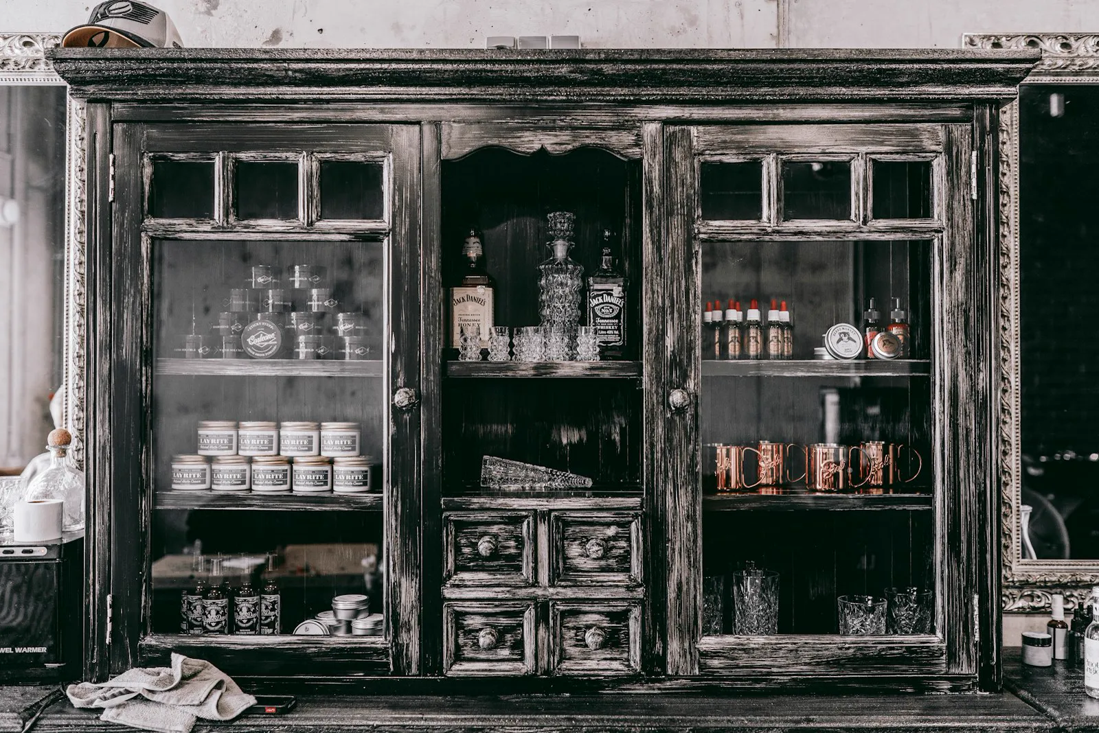 Aged wooden display cabinet with glazed doors and small drawers
