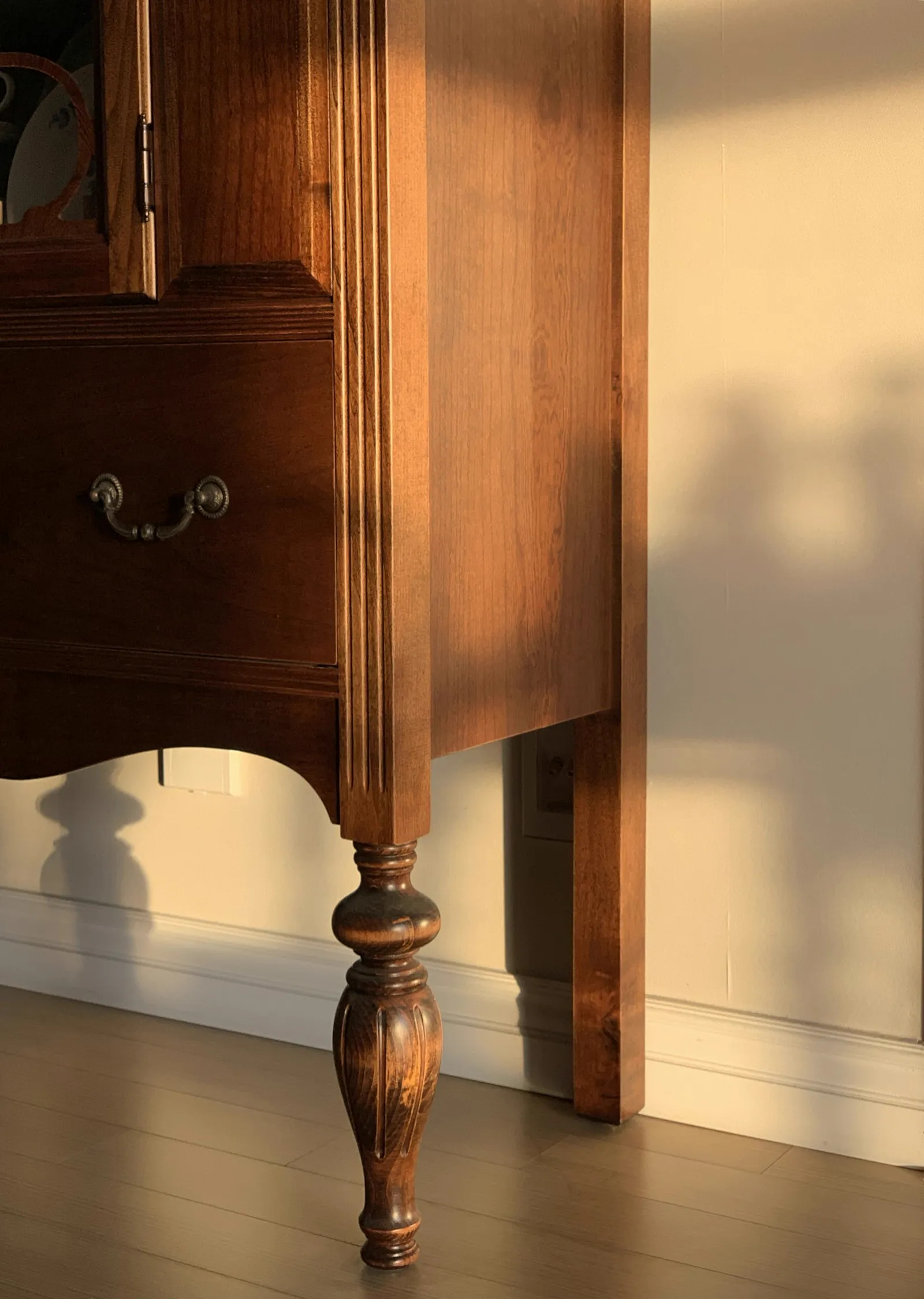 Antique dresser with a brass drop pull and turned front foot