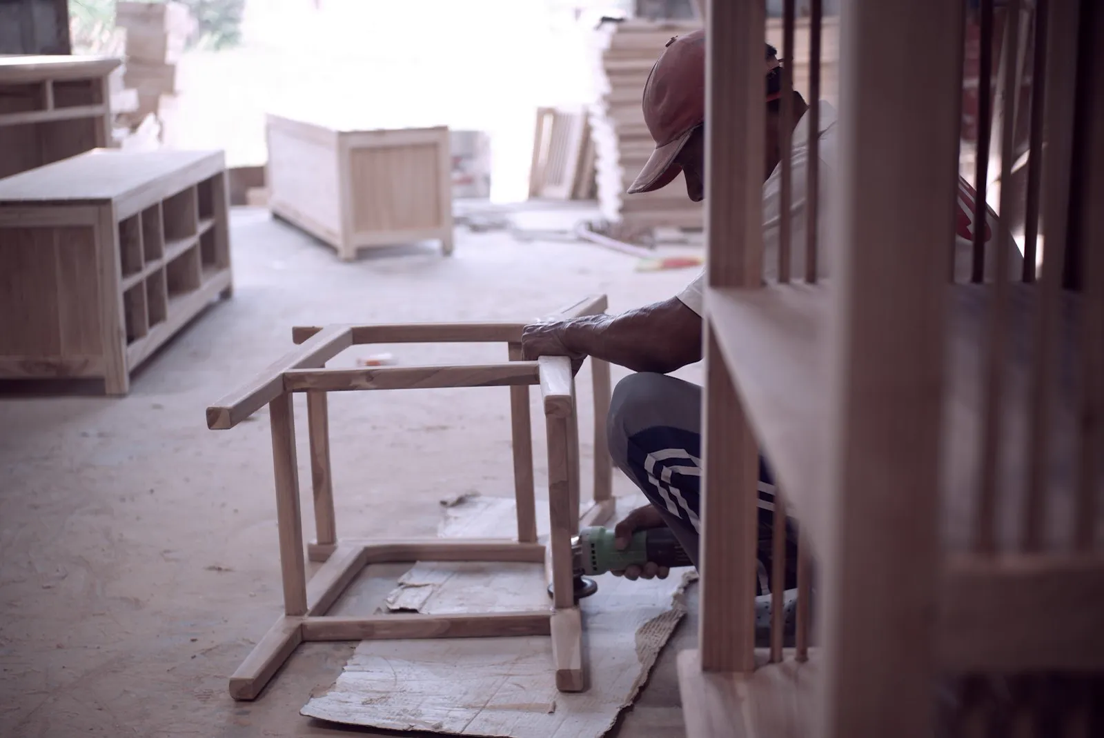 Craftsperson repairing the frame of a wooden chair in the workshop