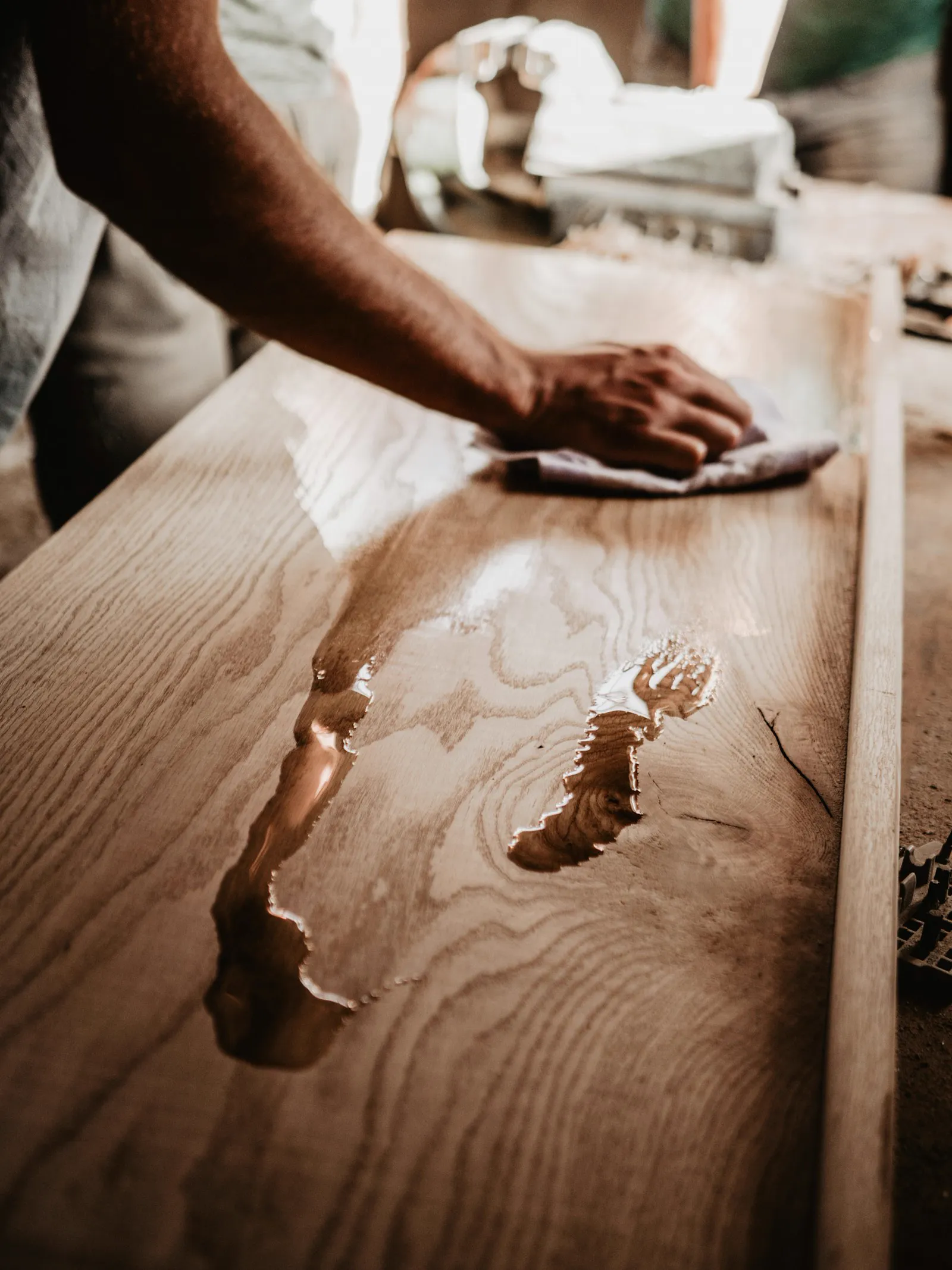 Hand rubbing a polished finish onto a wooden tabletop